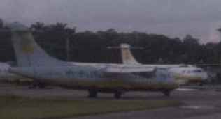 A cropped, closer view of one of the parked aircraft showing the Aero Caribbean livery in white and yellow.
